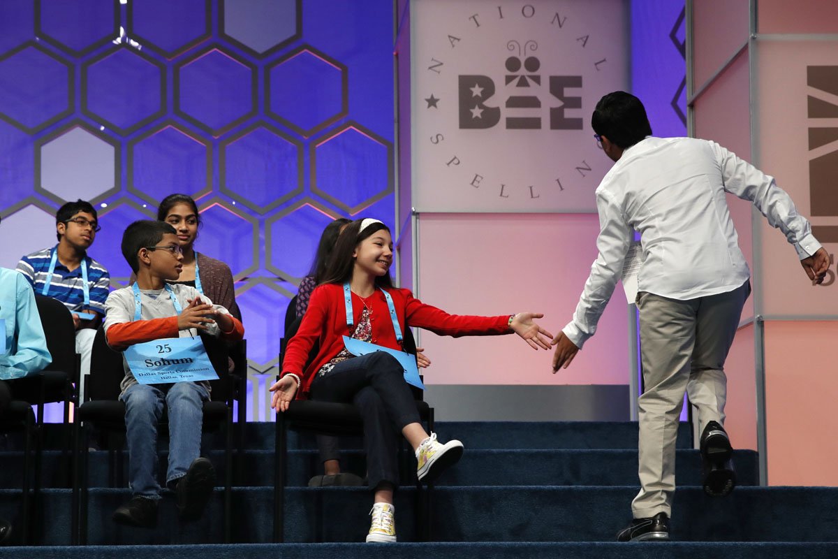 Tejas Muthusamy, 14, of Glen Allen, Va., right, is congratulated by fellow finalists including Melodie Loya, 12, of Bainbridge, N.Y., left, after Muthusamy spelled a word correctly during the 90th Scripps National Spelling Bee in Oxon Hill, Md., Thursday, June 1, 2017. (AP Photo/Jacquelyn Martin)