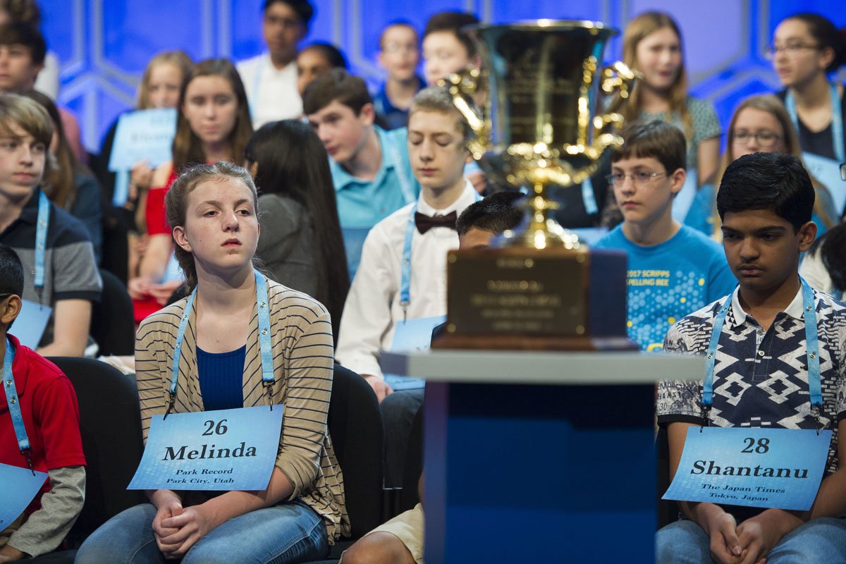 Melinda Buhlman, 13, from Heber, Utah, left, looks at the winner's trophy during the 90th Scripps National Spelling Bee in Oxon Hill, Md., Wednesday, May 31, 2017.  (AP Photo/Cliff Owen)