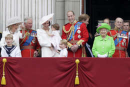 Britain's Queen Elizabeth II smiles with Prince Philip, right, Prince William, centre, his son Prince George, front, Kate, Duchess of Cambridge holding Princess Charlotte, centre left, The Prince of Wales and The Duchess of Cambridge, left, on the balcony during the Trooping The Colour parade at Buckingham Palace, in London, Saturday, June 11, 2016. Hundreds of soldiers in ceremonial dress have marched in London in the annual Trooping the Colour parade to mark the official birthday of Queen Elizabeth II. The Trooping the Colour tradition originates from preparations for battle, when flags were carried or "trooped" down the rank for soldiers to see. (AP Photo/Tim Ireland)