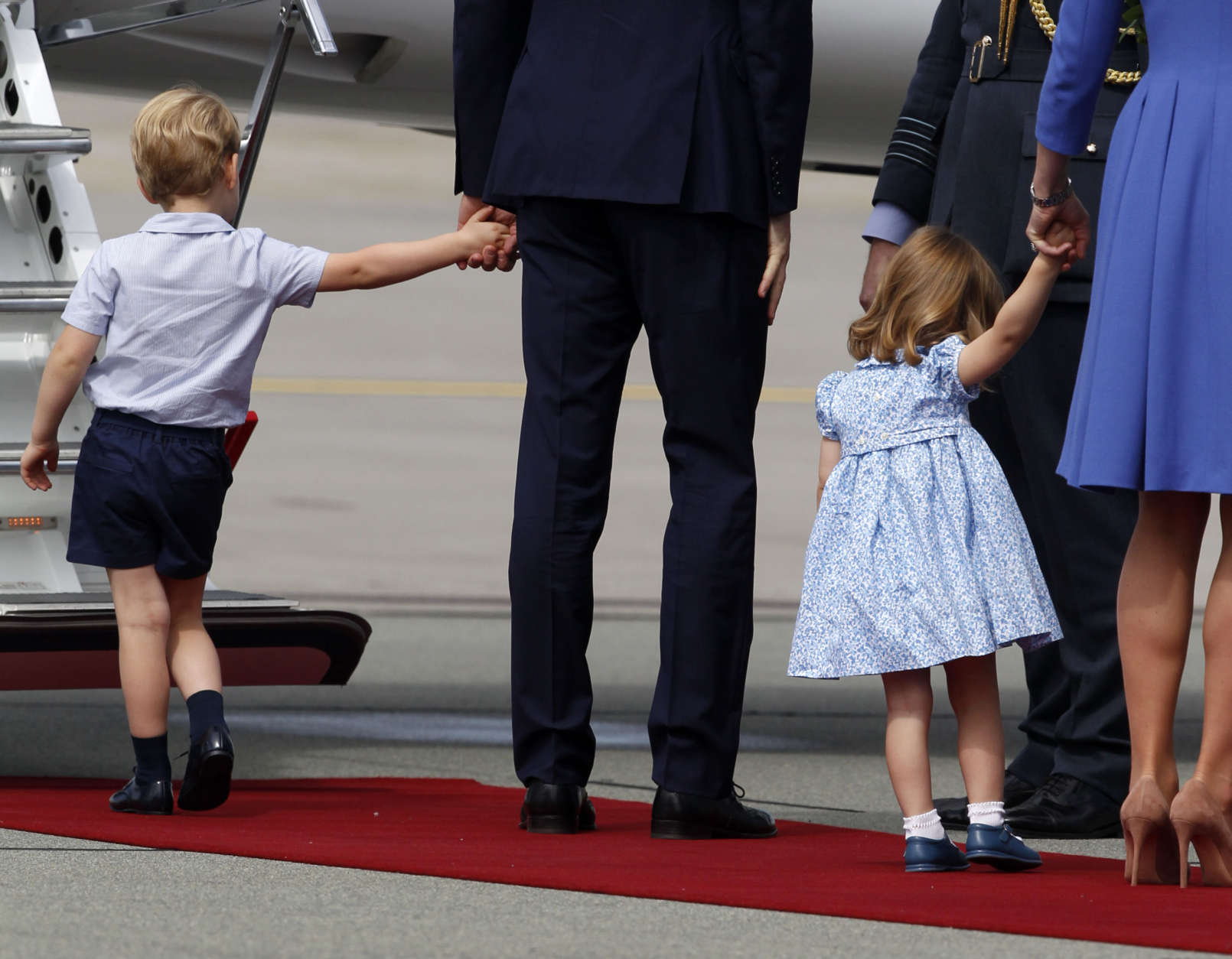 Britain's Prince William, center, and his wife Kate, the Duchess of Cambridge, right, walk with their children Prince George, left, and Princess Charlotte as they leave the airport in Warsaw, Poland, Wednesday, July 19, 2017. The British royal couple is in Poland with their children on a goodwill visit intended to seal friendly ties after Britain leaves the European Union. (AP Photo/Czarek Sokolowski)