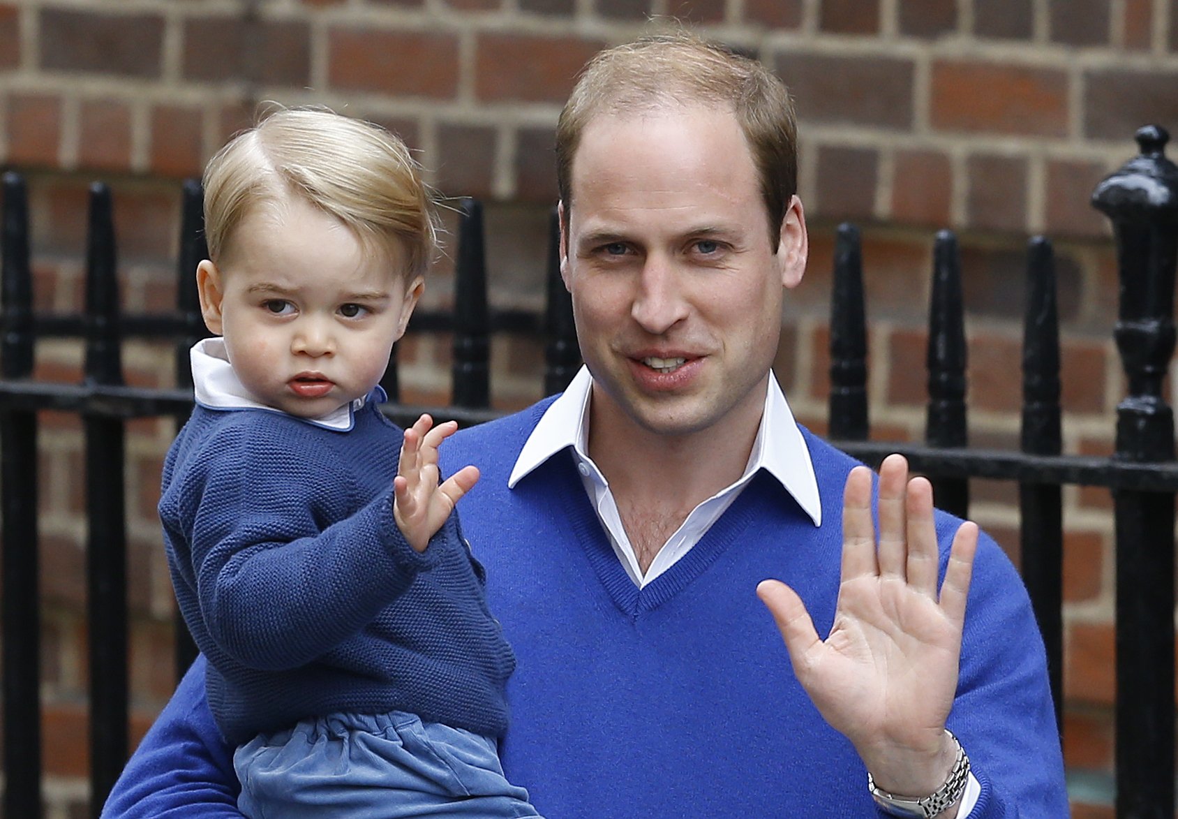 FILE - In this Saturday, May 2, 2015 file photo, Britain's Prince William and his son Prince George wave as they return to St. Mary's Hospital's exclusive Lindo Wing, London. William's wife, Kate, the Duchess of Cambridge, gave birth to a baby girl on Saturday morning.  Britains royals on Wednesday July 22 ,2015 celebrate the second birthday of George, the first child of Prince William and his wife, Kate.   (AP Photo/Kirsty Wigglesworth, file)