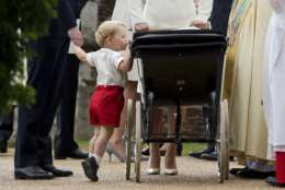 Britain's Prince George gets up on tip-toes to peek into the pram of his sister Princess Charlotte flanked by his parents Prince William and Kate the Duchess of Cambridge as they leave after Charlotte's Christening at St. Mary Magdalene Church in Sandringham, England, Sunday, July 5, 2015.  (AP Photo/Matt Dunham, Pool, File)