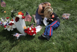 Brittany Jacobs of Hertford, North Carolina, embraces her son, Christian Jacobs, 6, while sitting next to the grave of her husband, U.S. Marine Corps Sgt. Chris Jacobs, in Section 60 at Arlington National Cemetery on Memorial Day May 29, 2017 in Arlington, Virginia. Part of the 3rd Assault Amphibian Battalion, 1st Marine Division, Sgt. Jacobs served in Aghanistan and Iraq and was killed during a training exercise in California in 2011. (Photo by Chip Somodevilla/Getty Images)