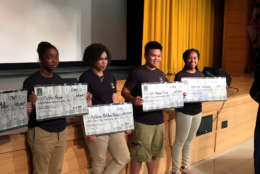Army-bound Oxon Hill High School seniors display checks representing the GI Bill money they earn for their post-Army education. (WTOP/Rich Johnson)
