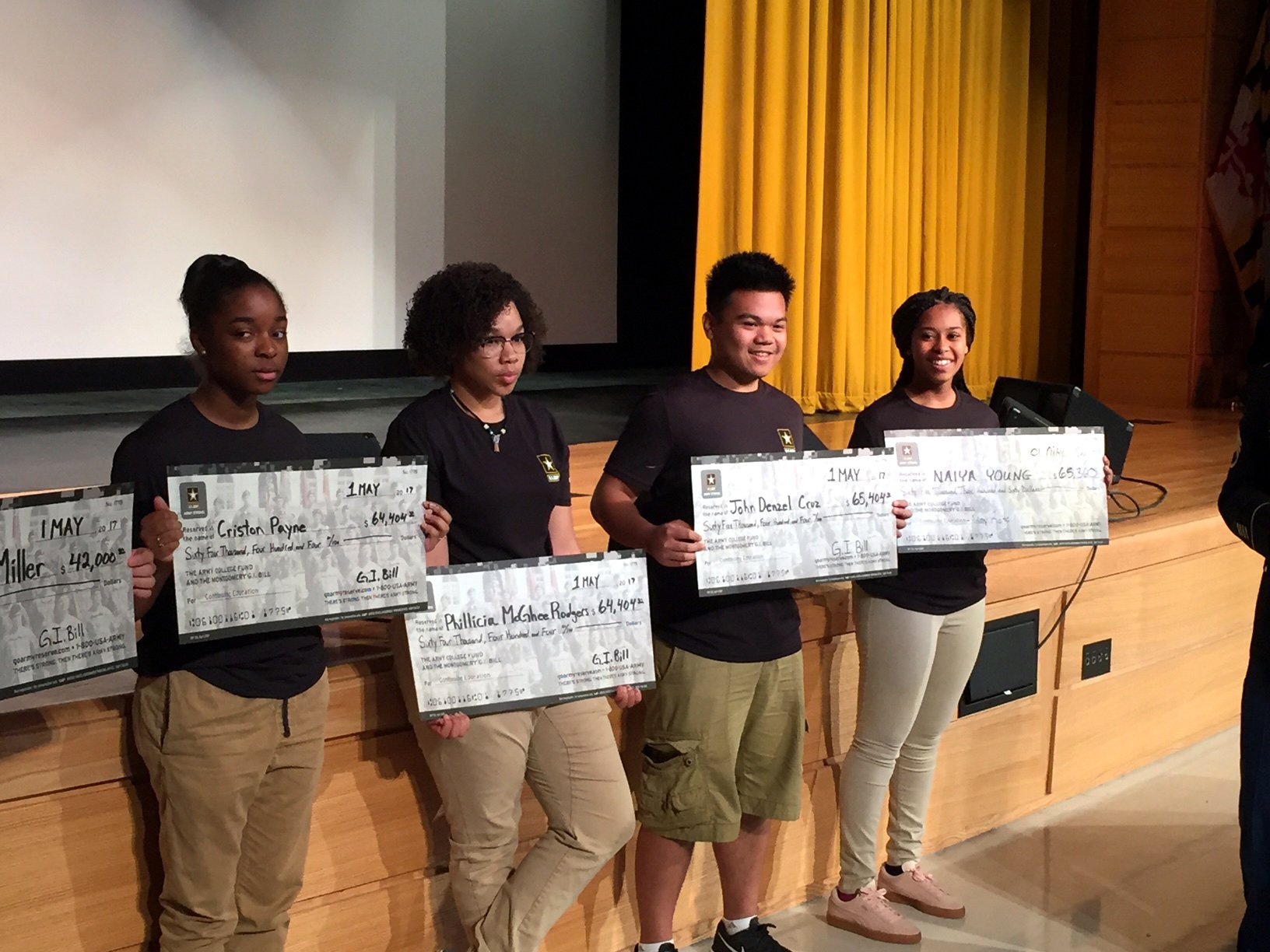 Army-bound Oxon Hill High School seniors display checks representing the GI Bill money they earn for their post-Army education. (WTOP/Rich Johnson)