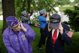 Herb Colie, left, who served with the 4th Battalion 60th artillery, and Jim Benning, rght, who served as a second class machinist's mate on the USS Oak Hill during the Vietnam War, cover their ears as John Marsigliano, back left, and Chris Moeller, both of the Sons of the American Legion, do a gun salute during a Memorial Day observance, Monday, May 29, 2017, in Bridgewater, N.J. (AP Photo/Julio Cortez)