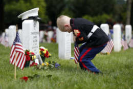 Christian Jacobs, 5, of Hertford, N.C., dressed as a Marine, works to place a flag in front of his father's gravestone on Memorial Day in Section 60 at Arlington National Cemetery in Arlington, Va., Monday, May 30, 2016. Christian's father Marine Sgt. Christopher James Jacobs died in a training accident in 2011. (AP Photo/Carolyn Kaster)