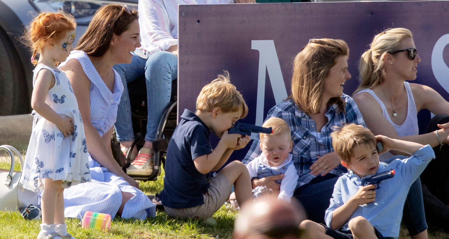 Britain's Kate, the Duchess of Cambridge, left, sits with Prince George and other unidentified spectators as they watch Prince William take part in the Maserati Royal Charity Polo Trophy at the Beaufort Polo Club, in Tetbury, England, Sunday June 10, 2018. (Steve Parsons/PA via AP)
