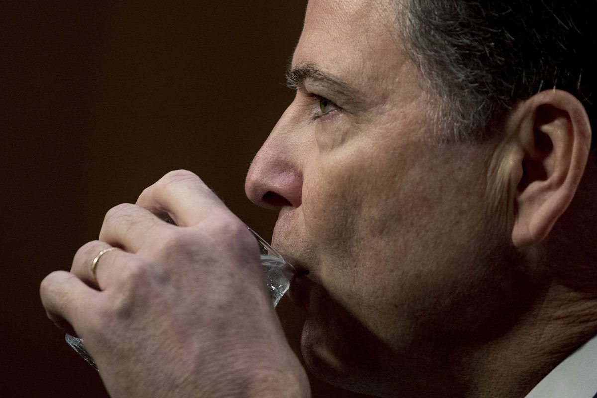 Former FBI director James Comey takes a drink of water as he testifies at a Senate Intelligence Committee hearing on Capitol Hill, Thursday, June 8, 2017, in Washington. (AP Photo/Andrew Harnik)