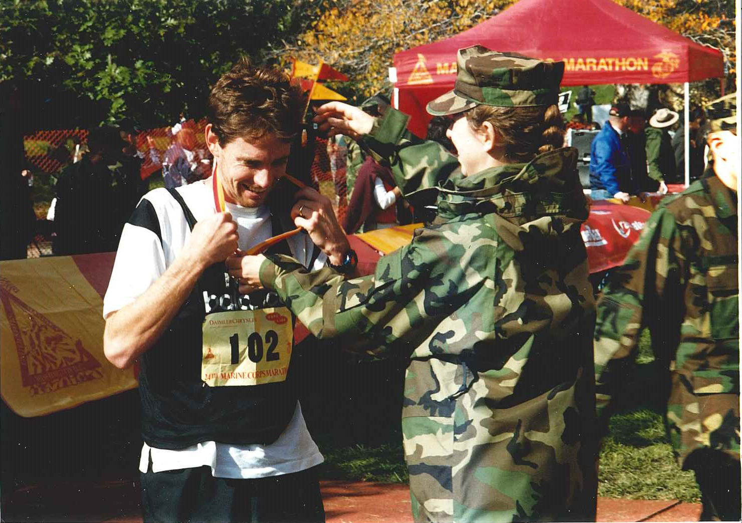 A Marine presents a medal to at finish at the 1999 Marine Corps Marathon. (Courtesy Marine Corps Marathon)