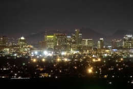 ADVANCE FOR WEEKEND OF MARCH 9-10--The Squaw Peak Mountains are seen behind the illuminated Phoenix skyline in this photo taken Thursday, Feb. 28, 2002, from South Mountain in Phoenix.  Astronomers say light pollution is a threat to the research and technology spinoffs that now pump nearly $1 billion into Arizona's economy each year.  (AP Photo/Matt York)