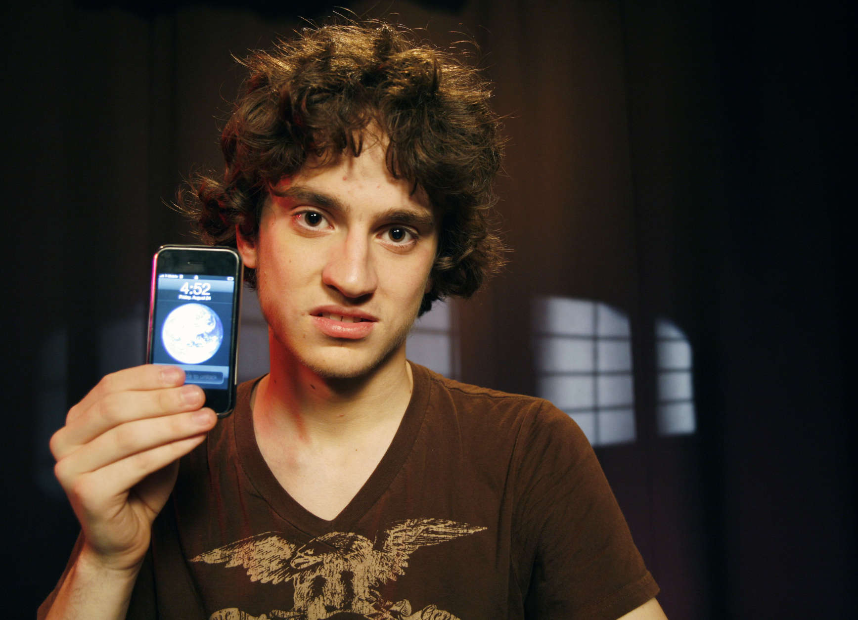 George Hotz, 17, holds an iPhone that he has unlocked and is using on T-Mobile's network, Friday, Aug. 24, 2007 in New York. Hotz has broken the lock that ties Apple's iPhone to AT&amp;T's wireless network, freeing the most hyped cell phone ever for use on the networks of other carriers, including overseas ones. (AP Photo/Jeff Christensen)