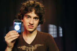 George Hotz, 17, holds an iPhone that he has unlocked and is using on T-Mobile's network, Friday, Aug. 24, 2007 in New York. Hotz has broken the lock that ties Apple's iPhone to AT&amp;T's wireless network, freeing the most hyped cell phone ever for use on the networks of other carriers, including overseas ones. (AP Photo/Jeff Christensen)