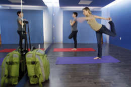 In this Friday, Jan. 27, 2012 photo, travelers Maria Poole, right, and Lindsey Shepard, practice yoga at San Francisco International Airport's new Yoga Room, in San Francisco. The quiet, dimly lit studio officially opened last week in a former storage room just past the security checkpoint at SFO's Terminal 2. Airport officials believe the 150-square-foot room with mirrored walls is the world's first airport yoga studio, said spokesman Mike McCarron. (AP Photo/Paul Sakuma)