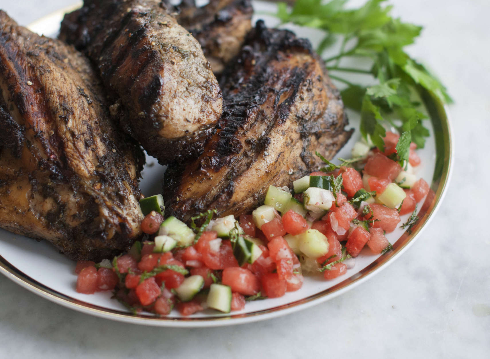 This April 14, 2014 photo shows grilled jerk chicken breast with watermelon salsa in Concord, N.H. Jerk refers both to a unique blend of seasonings and to a method of slow cooking. (AP Photo/Matthew Mead)