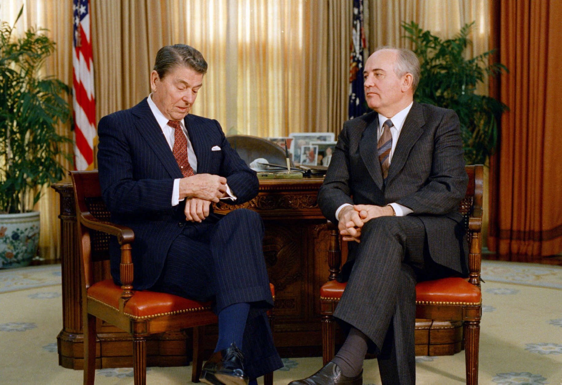 President Ronald Reagan checks his watch while talking with Soviet leader Mikhail Gorbachev during a meeting in the White House Oval Office, Dec. 9, 1987.  Reagan and Gorbachev were meeting for the third time in two days.  (AP Photo/J. Scott Applewhite)