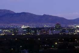 The Albuquerque, N.M. skyline lights up at dusk, shown in this photo from Oct. 1992. Albuquerque's water supplies, incuding the San Juan-Chama river water, will last the city for two or three decades, supporting a population of a little over 700,000. It now serves 470,000, according to city water resource manager Norman Gaume. (AP Photo/Eric Draper)