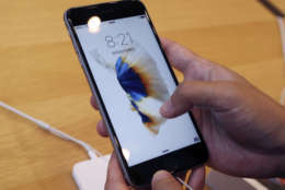 A customer tries new iPhone 6s on display at an Apple store in Tokyo Friday, Sept. 25, 2015. Apple is counting on sales of the new iPhones to maintain its position as one of the most profitable, and valuable, companies in the world. (AP Photo/Koji Sasahara)