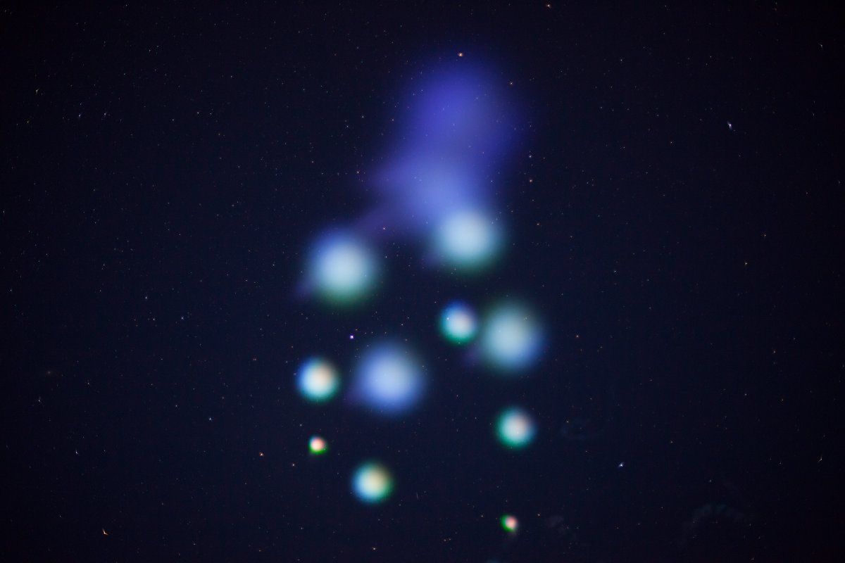 Vapor canisters released by the rocket left ethereal blue-green clouds. (Courtesy NASA)