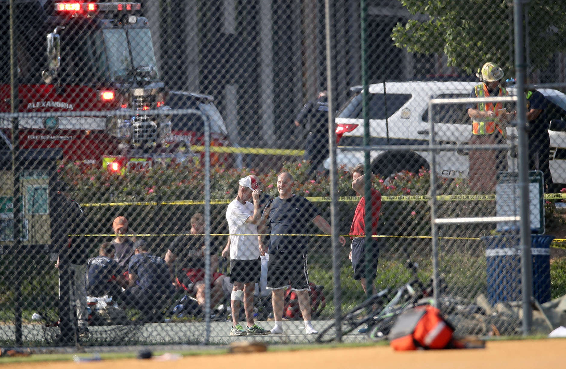 ALEXANDRIA, VA - JUNE 14: Investigators and men dressed in baseball gear gather at Eugene Simpson Field, the site where a gunman opened fire June 14, 2017 in Alexandria, Virginia. Multiple injuries were reported from the instance, the site where a congressional baseball team was holding an early morning practice, including House Republican Whip Steve Scalise (R-LA) who was reportedly shot in the hip. (Photo by Win McNamee/Getty Images)