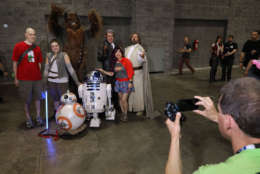 Attendees have their photograph taken with people dressed as Star Wars characters during the first day of Awesome Con at the Walter E. Washington Convention Center June 16, 2017 in Washington, DC. Thousands of fans of popular culture, fantasy and science fiction will gather for the three-day convention that includes comic books, collectibles, toys, games, original art, cosplay and Marvel Comics legend Stan Lee.  (Photo by Chip Somodevilla/Getty Images)