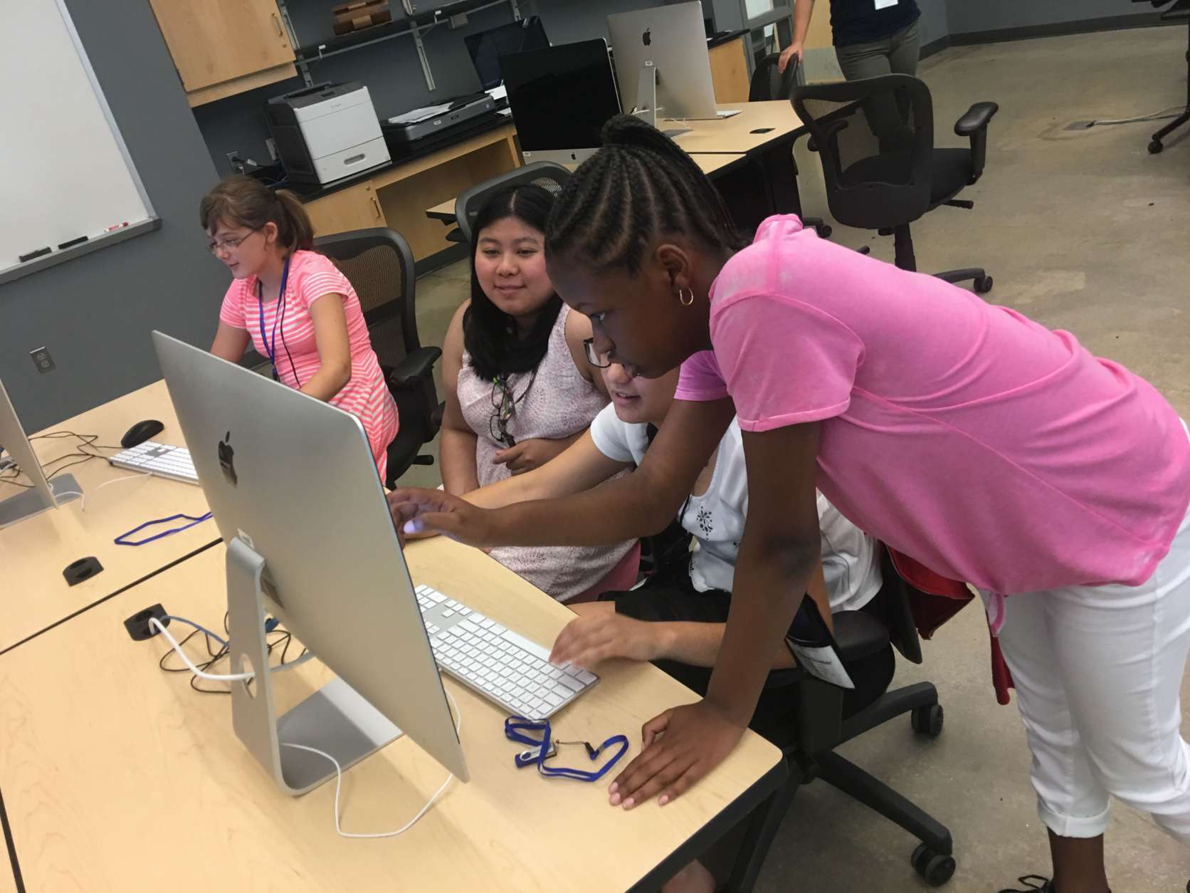 Phylisha Bower works with other girls in the class on editing their games with instructor Nina Tungjairob, who is seated in the middle. (WTOP/Kristi King)