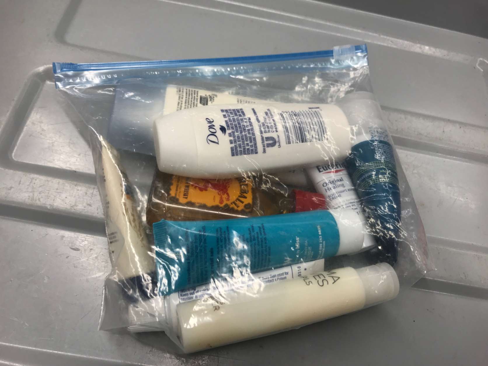 The 3-1-1 liquids rule says liquids, aerosols, gels, creams and pastes can be carried on, if the container holds 3.4 ounces or less. One clear, plastic zip-top bag per passenger. (WTOP/Neal Augenstein)