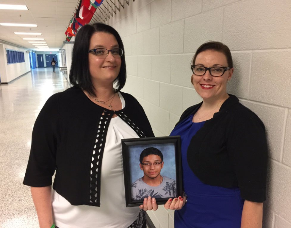 Kimberly Fleming, left, and Erica Plunkett, of the David J. Cobb Foundation, attend the signing of two new Virginia laws that deal with mental health and bullying in schools. They hold a picture of David Cobb, who killed himself when he was 17. (WTOP/Kristi King)