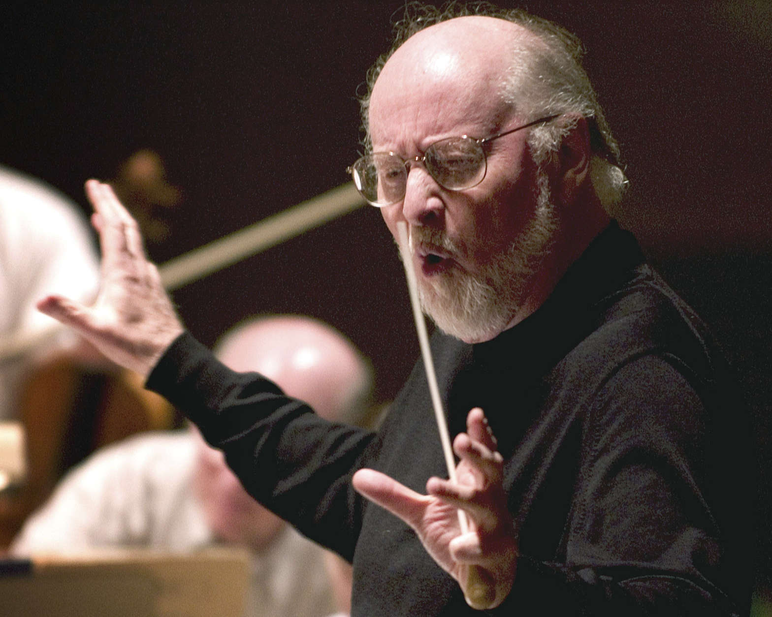 FILE - In this Tuesday, May 18, 2004 file photo composer John Williams leads the Boston Pops orchestra during a rehearsal in Boston. Williams, an Oscar- and Grammy-winning composer, who wrote the score for Star Wars: The Force Awakens, will help Pops conductor Keith Lockhart lead a performance of selections from the hit movies soundtrack as part of the orchestra's spring concert schedule. (AP Photo/ Robert E. Klein, File)