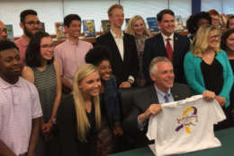 Virginia Gov. Terry McAuliffe signs two laws  at Forest Park High School in Woodbridge on June 6, 2017, that deal with mental health and bullying in schools. (WTOP/Kristi King)