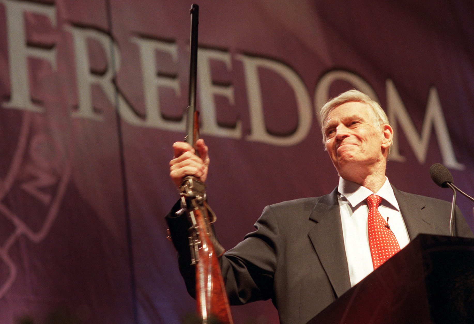 National Rifle Association (NRA) President Charlton Heston holds up a rifle during his address at the 131st NRA convention at the Reno-Sparks Convention Center in Reno, Nevada, April 27, 2002. Heston announced that he would remain president of the NRA for an unprecedented fifth term. (Photo by Candice Towell/Getty Images)