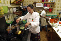 Iliana de la Vega, who runs the internationally known Oaxacan resturaunt El Naranjo, cooks a stuffed ancho chile in her resturaunt's kitchen in Oaxaca City Thursday, Dec. 12, 2002.  Behind are chefs Lucio Morales, right, and Marcos Velazquez. City officials decided this week to prohibit the golden arches from doing business under the historic stone archways of Oaxaca's 16th century central plaza, also known as the zocalo. The battle has divided this picturesque community between those who want to preserve its cultural identity and others who simply want a job. (AP Photo/Gregory Bull)