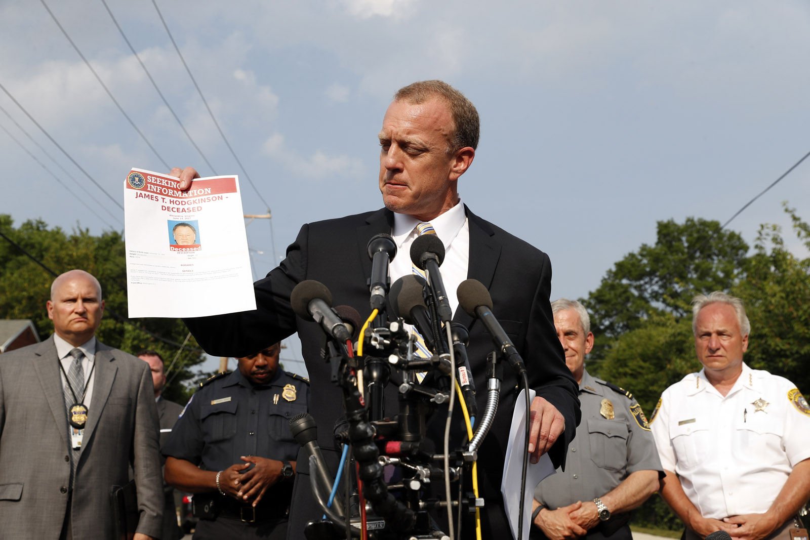 FBI Special Agent in Charge Tim Slater holds up a flyer looking for information about the deceased suspect James T. Hodgkinson, during a media availability Wednesday, June 14, 2017, in Alexandria, Va. A rifle-wielding attacker opened fire on Republican lawmakers as they practiced for a charity baseball game, critically wounding House GOP Whip Steve Scalise of Louisiana and hitting aides and Capitol police as congressmen and others dove for cover.  (AP Photo/Alex Brandon)