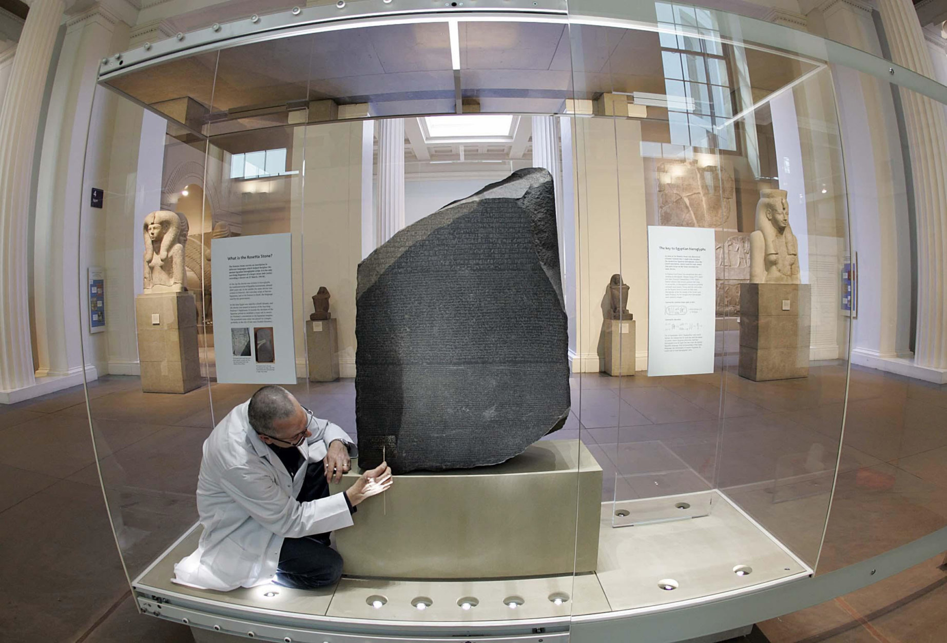 The Rosetta Stone undergoes the last stages of its conservation by Senior Stone Conservator Nic Lee, in the Egyptian Sculpture Gallery at The British Museum, in London, Tuesday July 6, 2004.  According to the museum, the new display will reflect the enduring relevance of the Rosetta Stone as a symbol of human understanding.  The Rosetta Stone is a granite slab dating from 196 BC bearing an inscription that was the key to the deciphering of Egyptian Hieroglyphics, it was found by French troops in 1799 near the town of Rashid (Rosetta) in Lower Egypt. ( Photo / Edmond Terakopian, PA) ** UNITED KINGDOM OUT  NO SALES  MAGS OUT **