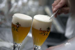 A workers scrapes the foam off of a glass of Brugse Zot beer before serving it at the Halve Maan Brewery in Bruges, Belgium on Thursday, May 26, 2016. The brewery has recently created a beer pipeline which will ship beer straight from the brewery to the bottling plant, two kilometers away, through underground pipes running between the two sources. (AP Photo/Virginia Mayo)