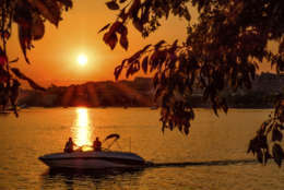 Recreational boaters watch the sunset on the Potomac River near the Francis Scott Key Bridge in Washington, Sunday, June 11, 2017. Temperatures in the nation's capital reached the mid-90s Sunday. (AP Photo/J. David Ake)