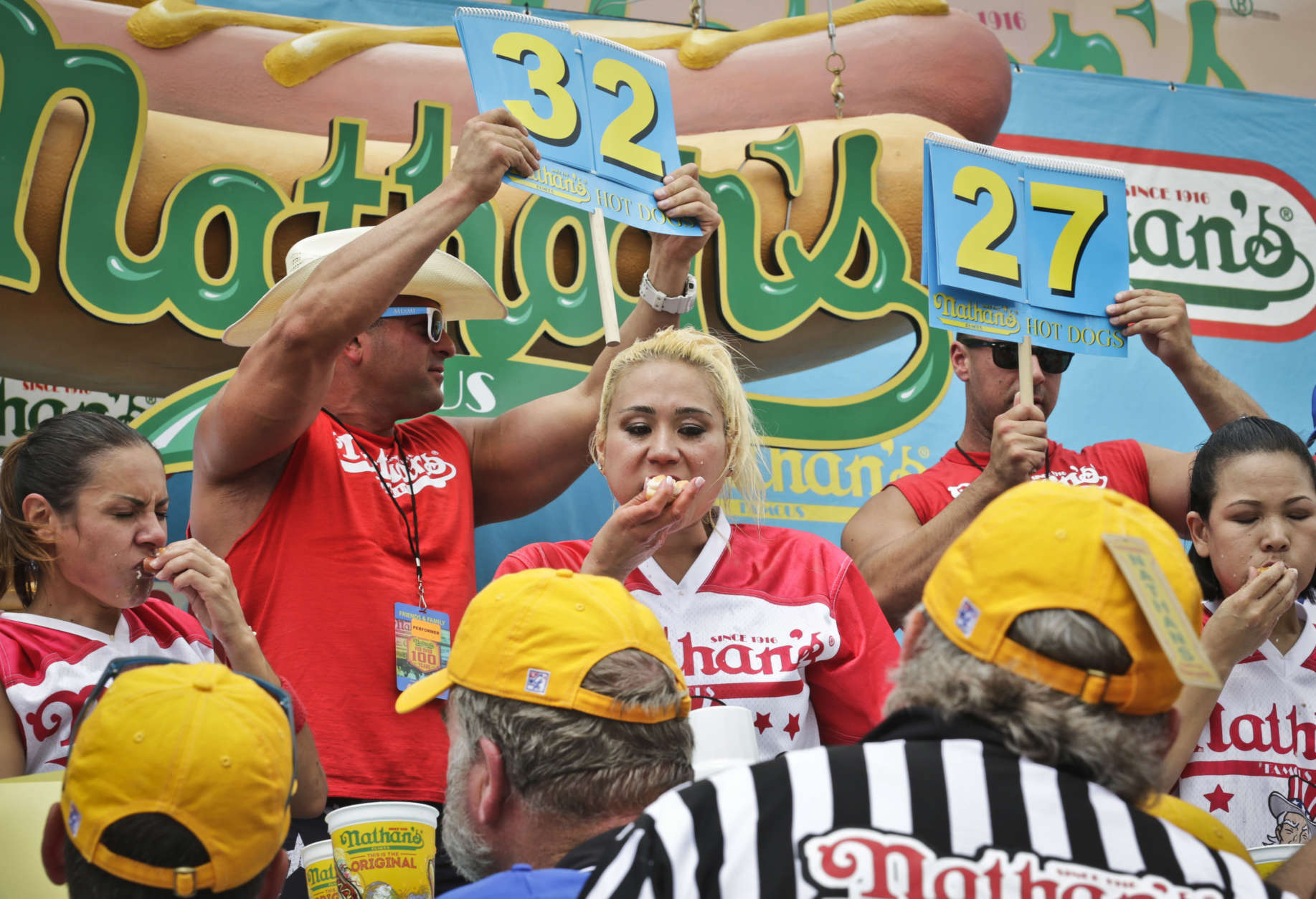 Miki Sudo, center, competes in the women's division of the Nathan's Famous Hot Dog Eating Contest on Tuesday, July 4, 2017, in New York. The Las Vegas woman ate 41 hot dogs and buns in 10 minutes to win her fourth straight title. (AP Photo/Bebeto Matthews)