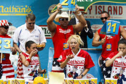Michelle Lesco, Miki Sudo and Sonya "The Black Widow Thomas compete in the Nathan's Famous Hotdog eating contest Tuesday, July 4, 2017, in Brooklyn, New York. Sudo won after eating 41 hotdogs in 10 minutes to claim her fourth win. (AP Photo/Michael Noble Jr.)