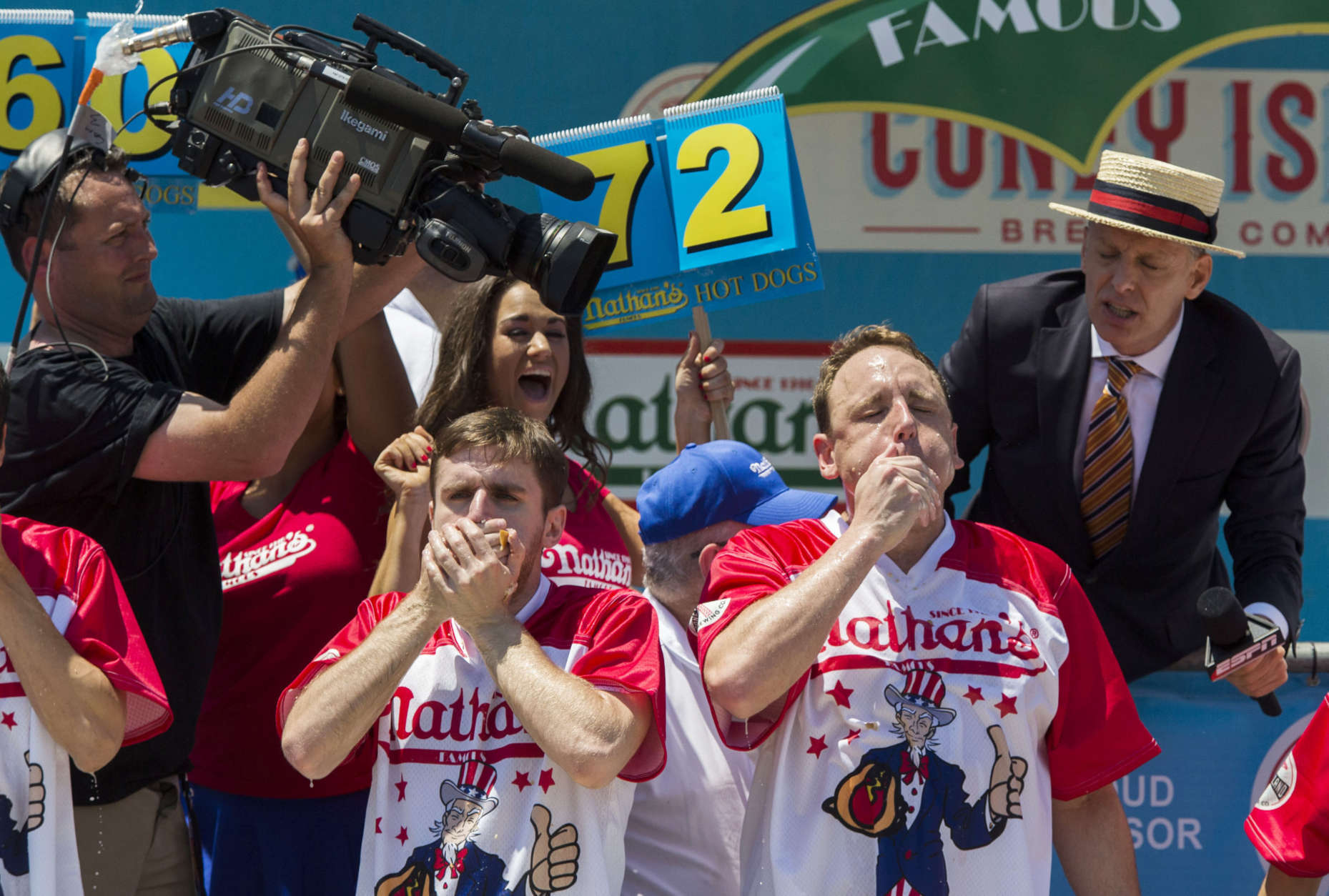 Carmen Ciccotti, left, and Joey Chestnut compete in the Nathan's Famous Hotdog eating contest Tuesday, July 4, 2017, in Brooklyn, New York. Chestnut ate 72 hotdogs in 10 minutes to claim his 10th win. (AP Photo/Michael Noble Jr.)