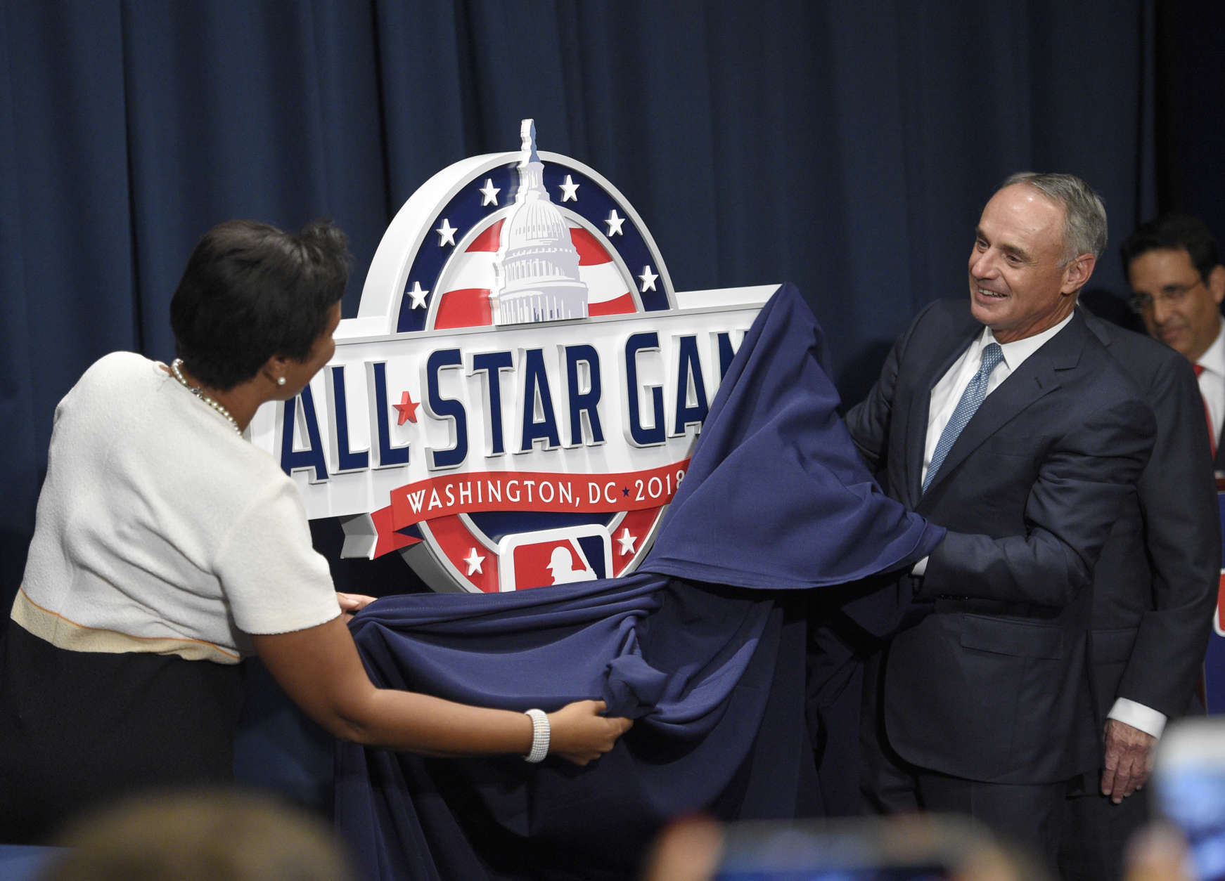 Muriel Bowser, Mayor of the District of Columbia, left, and Rob Manfred, Commissioner of Baseball, right, unveil the 2018 MLB All-Star Game logo at a baseball news conference to unveil the logo, Wednesday, July 26, 2017, in Washington. (AP Photo/Nick Wass)