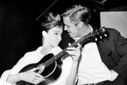 British actress Audrey Hepburn strums a guitar with her co star George Pappard between takes on the set of "Breakfast in Tiffany's" at a film studio in Hollywood on Dec. 7, 1960. (AP Photo)