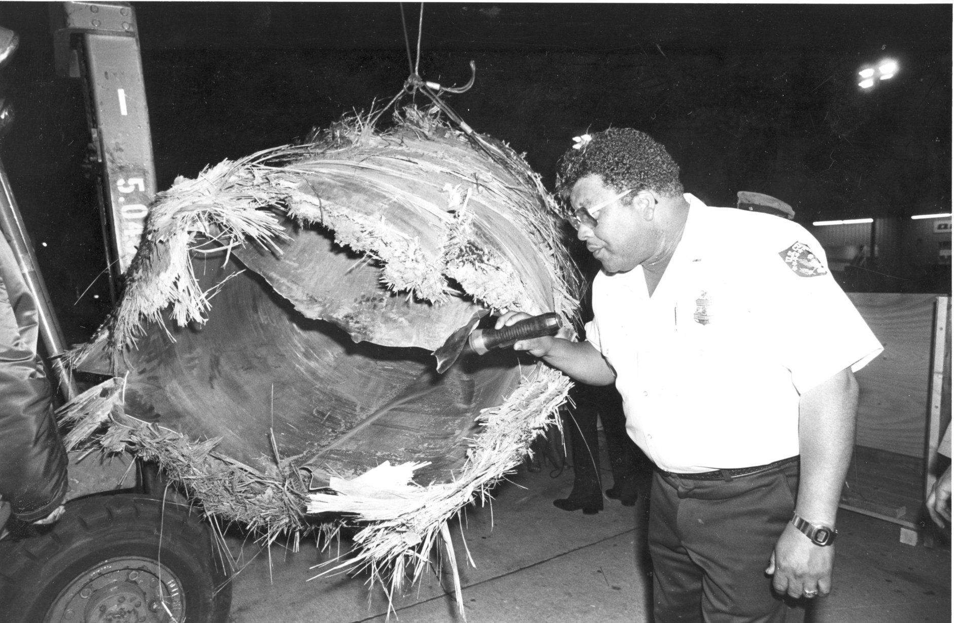 U.S. Customs official Oliver Seymour inspects the largest piece of the downed Skylab at the San Francisco International Airport, Ca., Wedenesday night, July 25, 1979.  The one-ton piece wreckage was found in Australia two weeks ago.   (AP Photo)