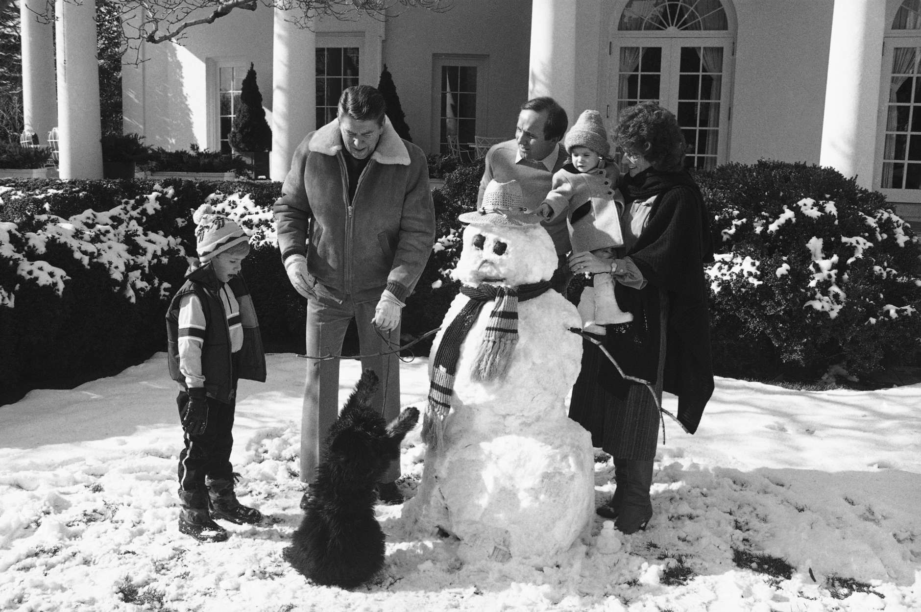 President Ronald Reagan, along with his son Michael?s family and the president?s dog Lucky, gather around a snowman on the White House grounds, Jan. 19, 1985. From left are, Michael?s son Cameron, the president, Michael, and his wife Colleen holding her daughter Ashley. (AP Photo/Ira Schwarz)