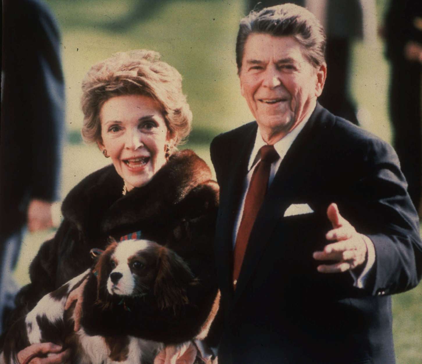 **FILE**   This December 1986 file photo shows first lady Nancy Reagan holding the Reagans' pet Rex, a King Charles spaniel, as she and President Reagan walk on the White House South lawn. (AP Photo/Dennis Cook, FILE)