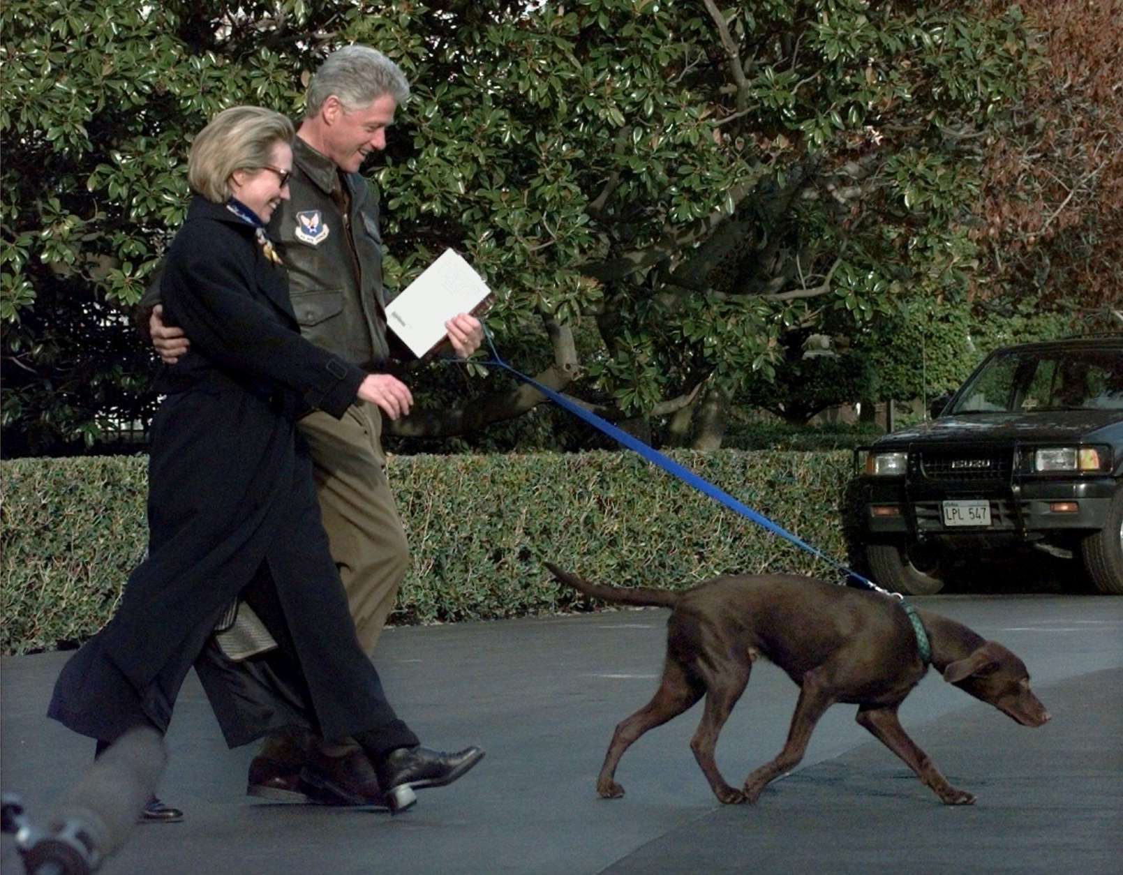 **FILE**   This March 13, 1998 file photo shows President Clinton, center, and first lady  Hillary Rodham Clinton with first puppy Buddy as they leave the White House for a presidential retreat at Camp David, Md.    (AP Photo/J.Scott Applewhite, FILE)