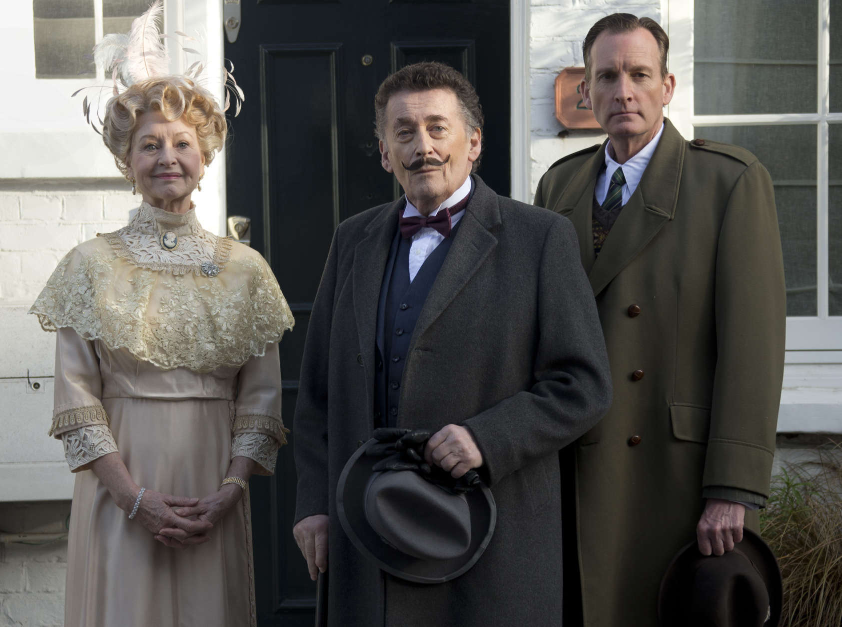 British actor Robert Powell, centre, dressed as the character Poirot, poses at a photo call for Agatha Christie's first ever play, Black Coffee. Alongside Powell are actors Liza Goddard, as Miss Caroline Amory, and Robin McCallum, right, as Poirots friend and confidante Captain Arthur Hastings. The photo call took place outside the former west London residence of author Christie, in Cresswell Place, London, Friday, Jan. 10, 2014. (Photo by Joel Ryan/Invision/AP)