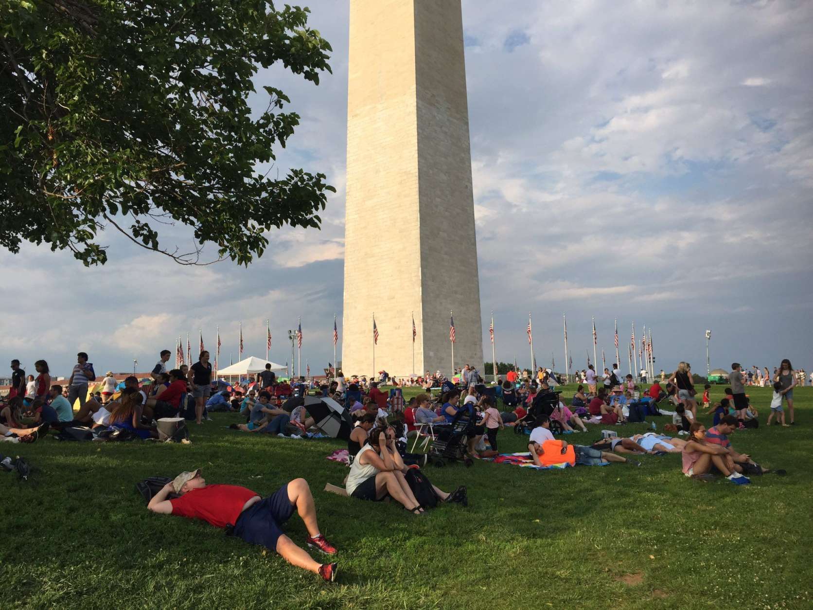 Some spectators near the Washington Monument were lucky enough to find shade. (WTOP/Michelle Basch)