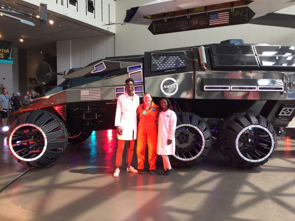 From left: Gabriel Parker, Dana Jondahl, and Bilan Walker pose with the Mars rover concept vehicle. (WTOP/Kristi King)