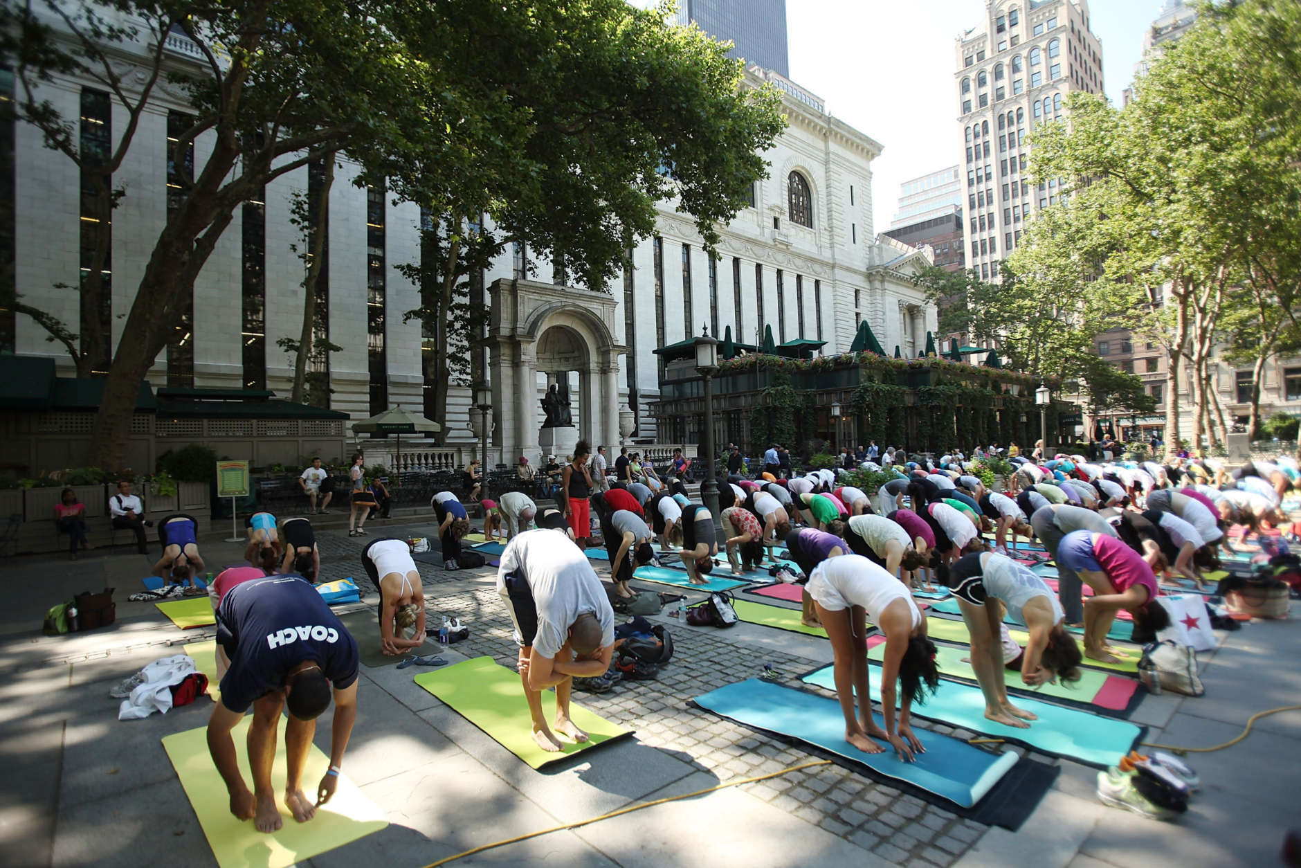 NEW YORK - JUNE 30:  People participate in a free outdoor yoga class in Bryant Park on June 30, 2009 in New York City.  After weeks of unseasonably wet weather, New York and New England have been experiencing dry and warm days which have brought about a flurry of activity in area parks and recreation areas.  (Photo by Spencer Platt/Getty Images)