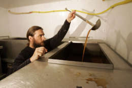 Orthodox priest, Father Antony, tests the ancient Russian fermented-bread drink known as kvas in a basement of the fifteenth-century Savvino-Storozhevsky Orthodox Monastery in Zvenigorod, 35 miles west of Moscow, Russia, Tuesday, July 1, 2008. For over 600 years, monks at the Savvino-Storozhevsky Monastery have been brewing kvas for themselves, and seven years ago began selling it. Unlike mass-produced varieties, the monastery's kvas has no preservatives and spoils within five days. (AP Photo/Dmitry Lovetsky)